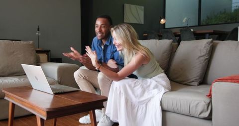 Joyful couple announcing engagement via video call at home