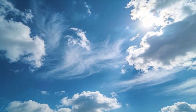 Sunlit Blue Sky with Layered Cirrus and Cumulus Clouds Creating Airy Expansive Cloudscape
