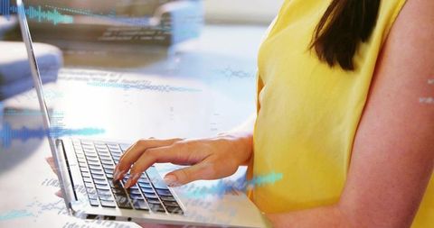 Woman typing on laptop with holographic code and waveform overlays for tech demo at home