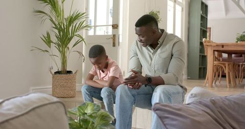 African american father comforting son on indoor steps — parent-child bonding at home