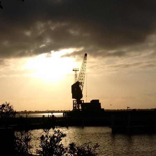 Silhouetted Harbor Crane at Sunset Over Water - Download Free Stock Images Pikwizard.com