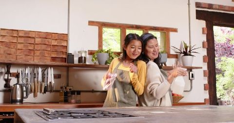 Mother and daughter enjoying kitchen chores in cozy home setting