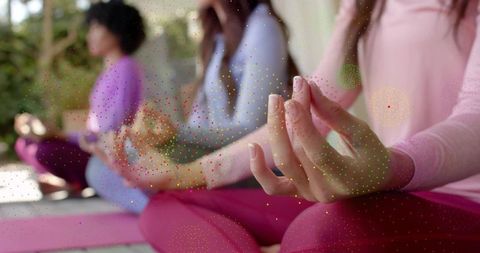 Women practicing mindful meditation with hand mudra on yoga mats natural light