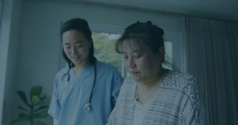 Nurse consulting patient with document in care room