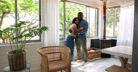 Happy Couple Embracing in Sunlit Cozy Sunroom