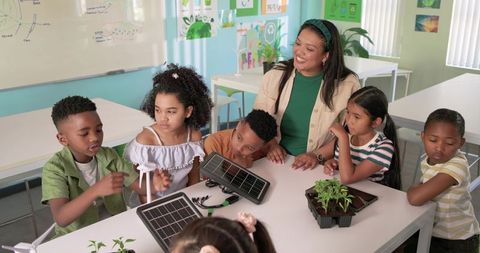 Teacher guiding students conducting renewable energy stem experiment with solar panels