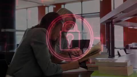 Two Women Studying in Library With Digital Lock Graphic Appearing Over Notes