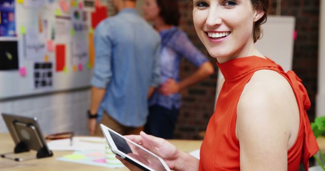 Young Professional Woman Smiling And Using Digital Tablet in Creative Office - Download Free Stock Images Pikwizard.com