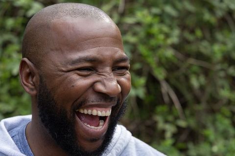 African american man laughing with open mouth closeup conveying joyful energy outdoors