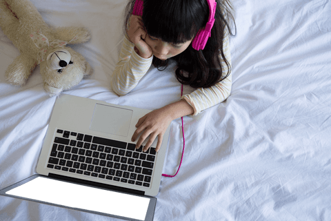 young girl with headphones using laptop on transparent white bed - Download Free Stock Videos Pikwizard.com