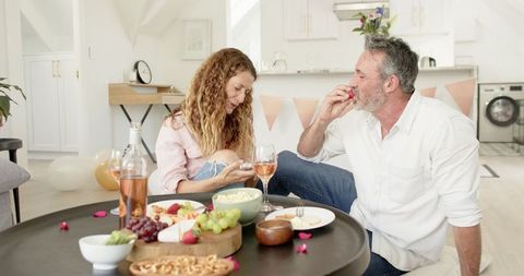 Mature Couple Enjoying Wine and Snacks at Home