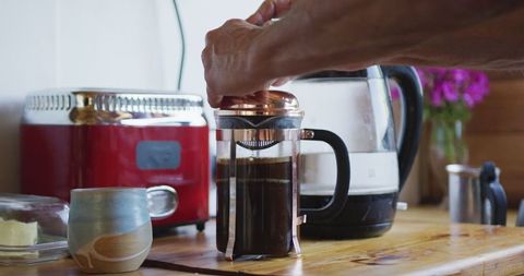 Senior Man Using French Press Making Morning Coffee