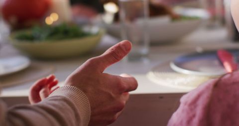 Family Bonding at Dinner Table Holding Hands in Prayer