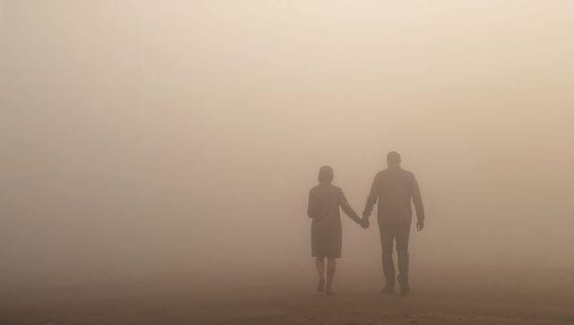 Couple walking hand in hand through dense fog minimalist tranquil silhouette romantic