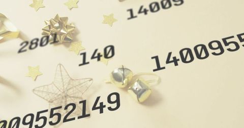 Gold holiday decorations flatlay featuring ribboned bells, metallic bow and wire star