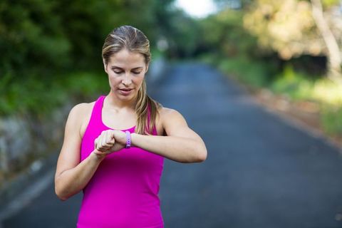 Woman Checking Fitness Tracker on Outdoor Jogging Path
