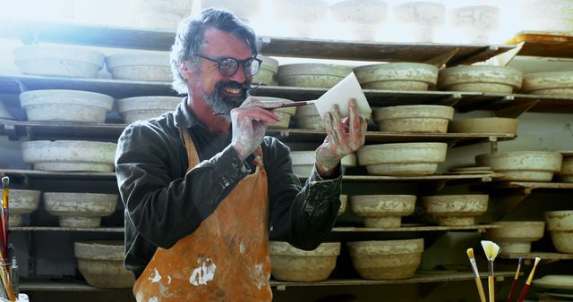 Happy Senior Male Potter Painting Ceramic Bowl in Workshop - Download Free Stock Images Pikwizard.com