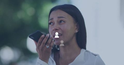 Concerned woman communicating via smartphone outdoors