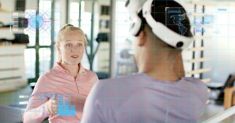 Female Trainer Coaching Client Wearing VR Headset in Gym with AR Overlays and Fitness Tech
