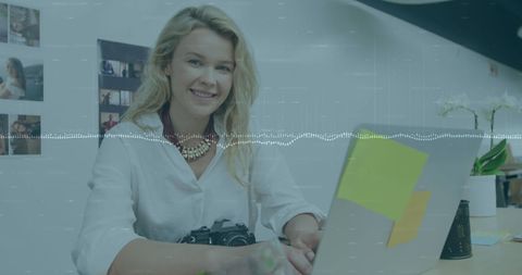 Professional businesswoman using laptop in creative office