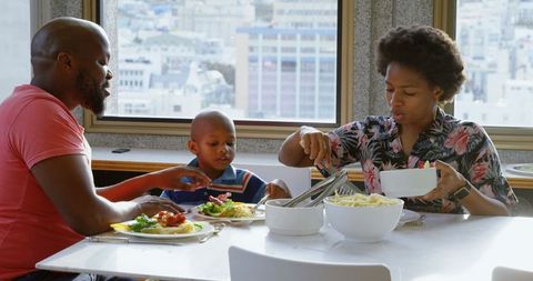 Family sharing meal at home with scenic urban view