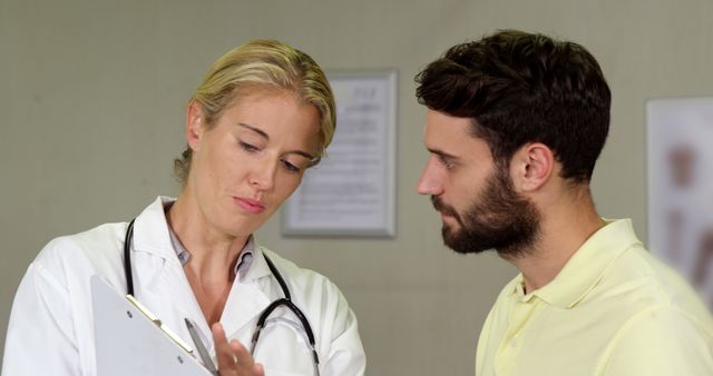 Female doctor consulting with male patient analyzing medical documents - Download Free Stock Images Pikwizard.com