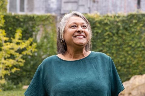 Happy African American Senior Woman in Ivy-Covered Garden