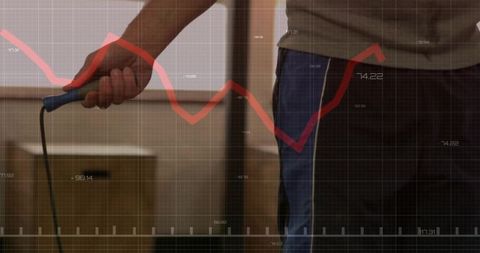 Storage worker holding blue-handled cord with red graph overlay representing logistics data