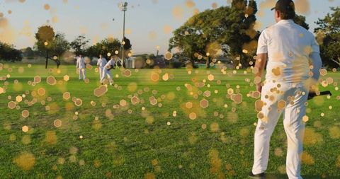 Sunlit cricket batsman facing fielders with golden bokeh overlay