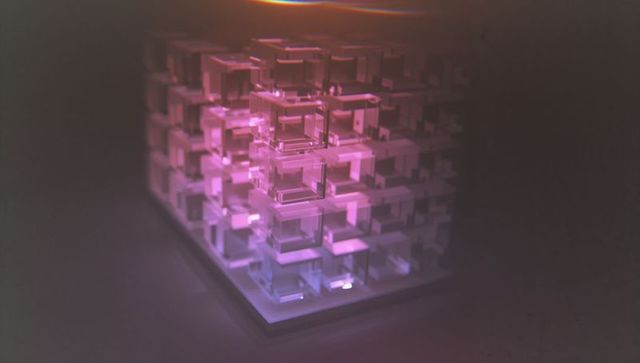 Futuristic glowing cubic sculpture in dark studio