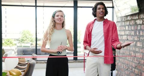 Office event ribbon cutting with happy team celebrating milestone