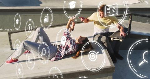 People Connected with Technology Overlaid with Digital Icons in Urban Skate Park