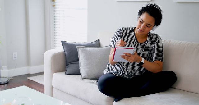 Young Woman Writing in Notebook on Sofa at Home - Download Free Stock Images Pikwizard.com