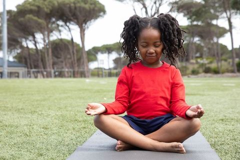 Mindful Child Meditating Outdoors on Turf