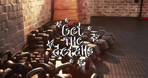 Kettlebells and hex dumbbells bathing in warm industrial light on brick-walled gym floor