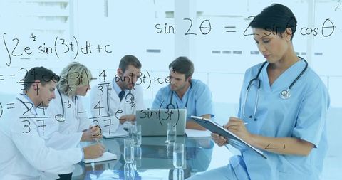Medical team collaborating around glass board while nurse in scrubs taking clipboard notes
