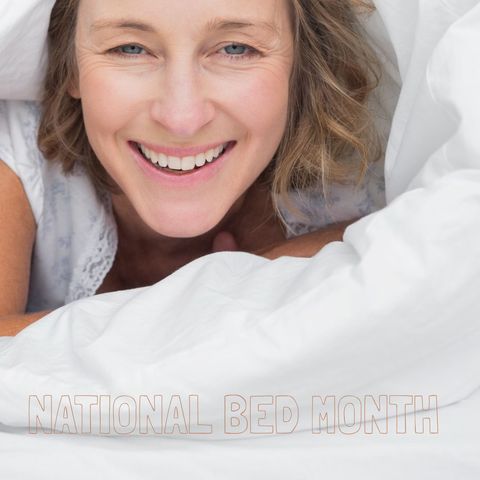 Smiling woman wrapped in bed linens for national bed month
