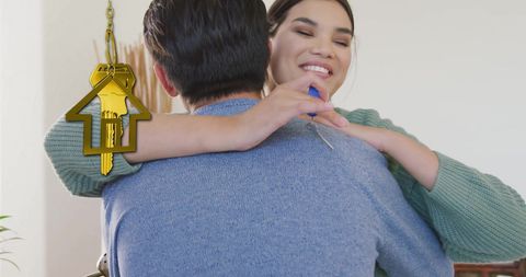 Happy couple embracing new home ownership with gold house key