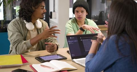 African American Coworkers Collaborating on Code with Laptop, Tablet and Notebooks