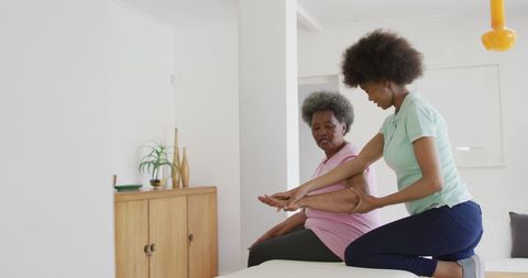 African American Physio Guiding Senior in Physical Exercise