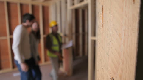 Architect Consulting with Couple During Home Construction Tour