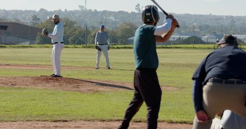 Neighborhood Baseball Pitcher Preparing Pitch as Batter Loading Swing with Umpire Watching