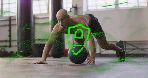Athletic Bald Man Balancing on Medicine Ball in Gym