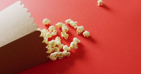 Box of Popcorn Spilled on Bold Red Background