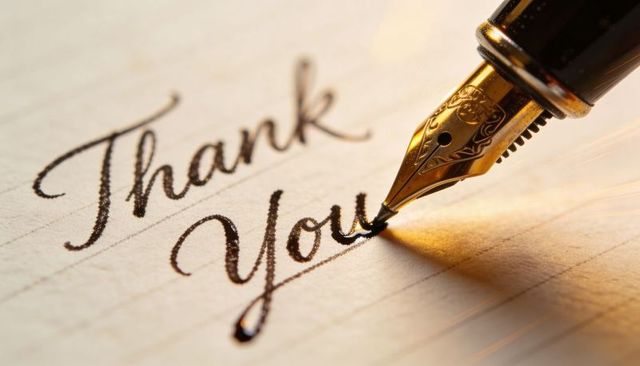 Gold fountain pen writing thank you calligraphy on cream lined paper, luxury card