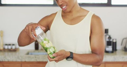 Man Preparing Green Smoothie in Modern Kitchen