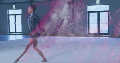 Graceful Gymnast Performing with Glitter Overlay on Gym Mat