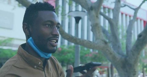 Man engaging in phone communication in urban plaza