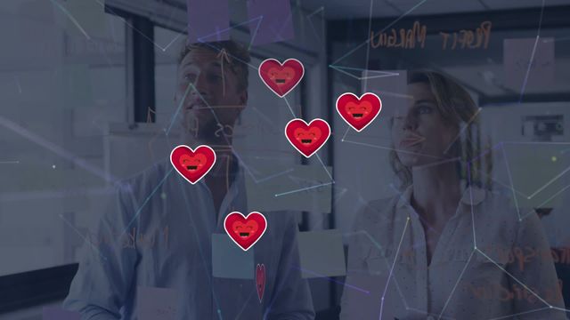 Caucasian man and woman standing in an office environment, engaged in strategic planning and communication. Transparent boards display interconnected networks symbolized by electronic animation with digital heart icons, denoting teamwork and positive relationships. This can be used for illustrating forward-thinking business environments, digital integration in corporate settings, or promotional material for companies highlighting connections and innovative approaches.