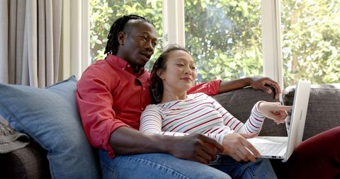 Happy Couple Relaxing on Sofa with Laptop in Sunlit Room - Download Free Stock Images Pikwizard.com
